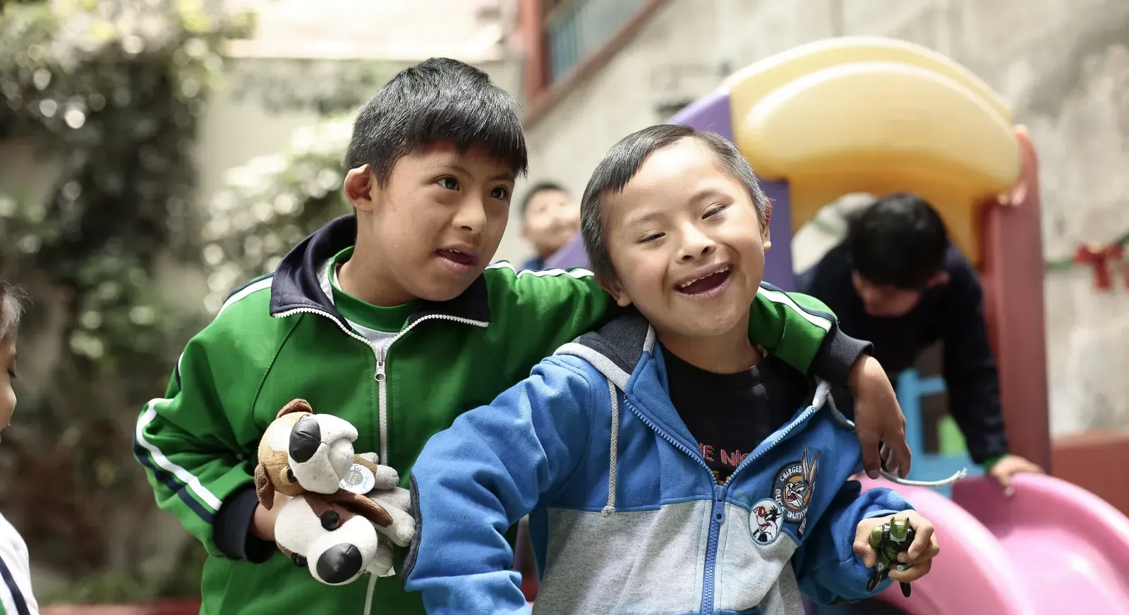 Two laughing children playing together at the Unámonos foundation in Arequipa, Peru